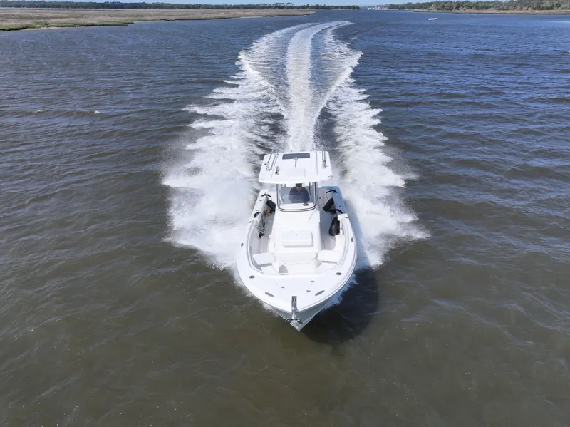 Slide: The Image of 2022 Edgewater 280CC boat cruising on open water, creating a dynamic wake. - 8