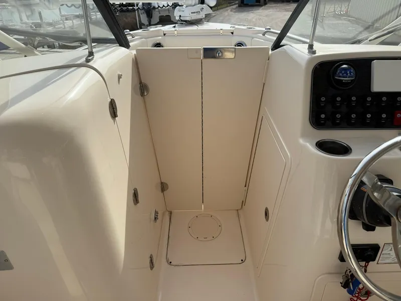 Slide: The Image of 2015 Grady-White Freedom 255 boat interior, featuring helm controls and steering wheel. - 10
