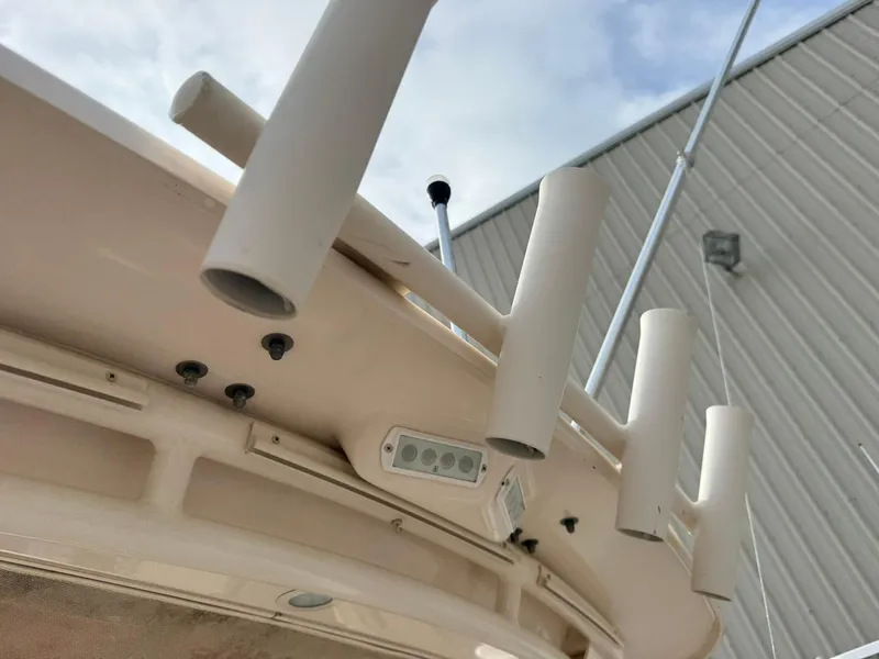 Slide: The Image of 2015 Grady-White Freedom 255 boat rod holders and equipment against a cloudy sky. - 19