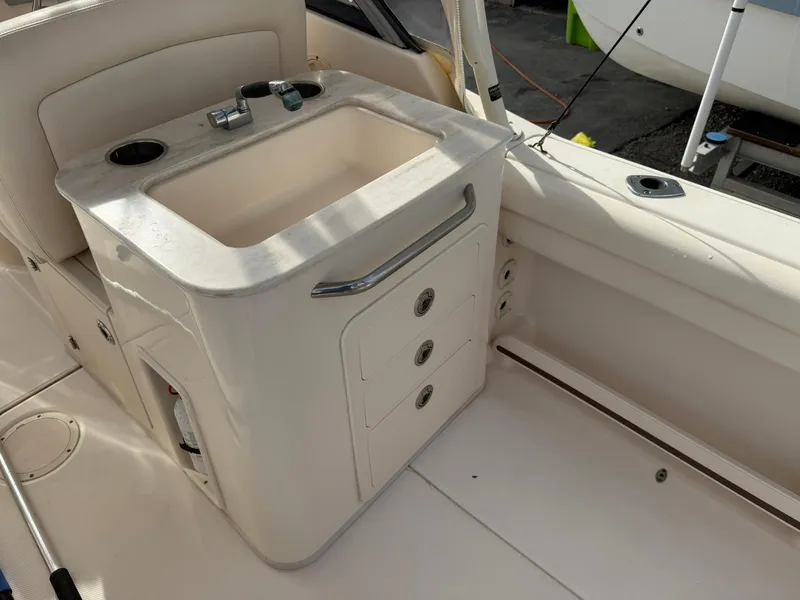 Slide: The Image of 2015 Grady-White Freedom 255 boat interior with sink and storage compartments. - 7