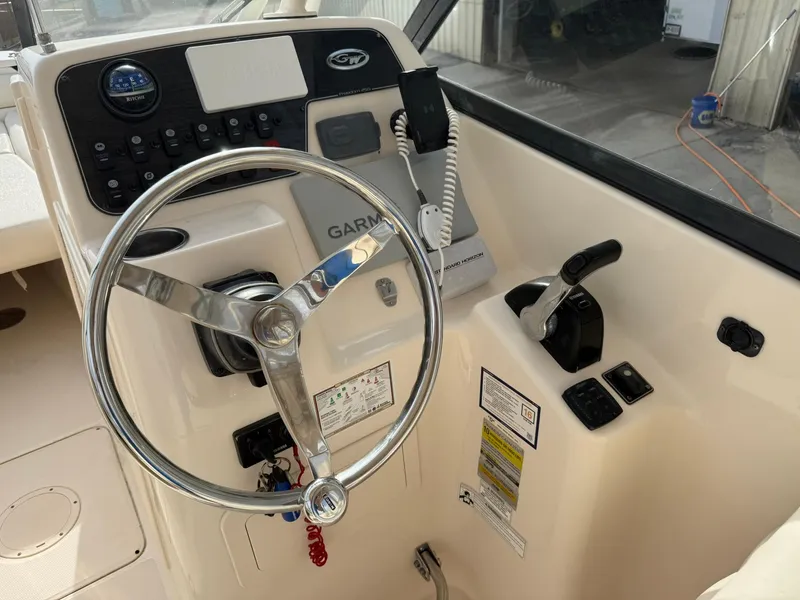Slide: The Image of 2015 Grady-White Freedom 255 boat helm with steering wheel and controls. - 8