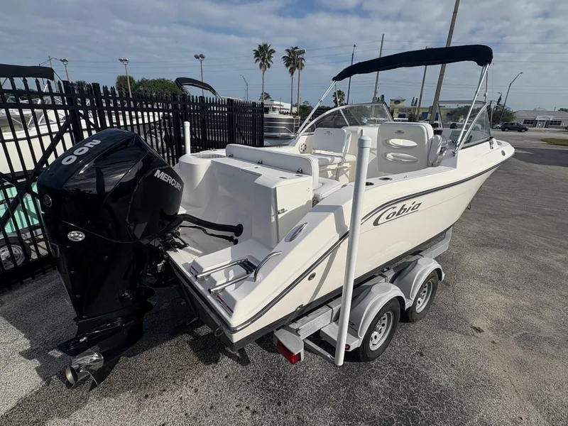 Slide: The Image of 2020 Cobia 220 Dual Console boat on trailer with Mercury outboard engine. - 3