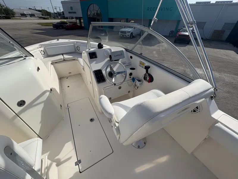 Slide: The Image of 2020 Cobia 220 Dual Console boat interior with steering wheel and seating. - 6