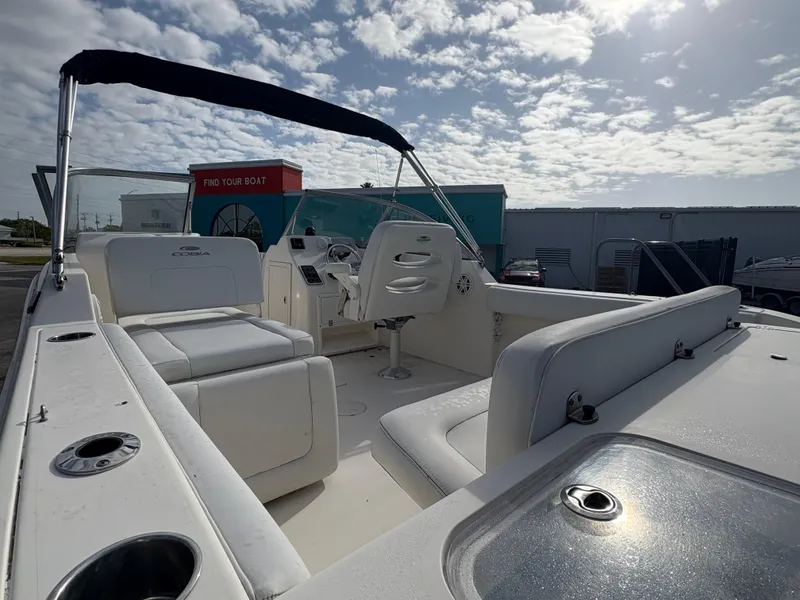 Slide: The Image of 2020 Cobia 220 Dual Console boat with seating, under a partly cloudy sky. - 7