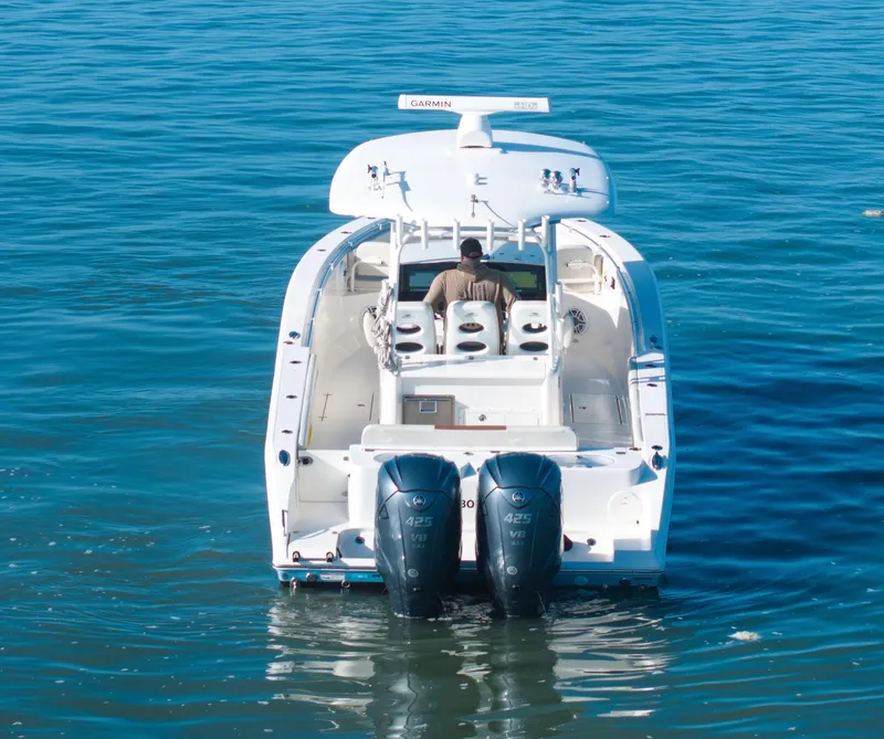 Slide: The Image of 2022 Cobia 350 Center Console boat on water, rear view with dual engines. - 15