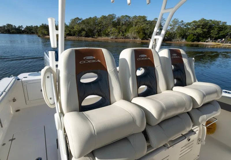 Slide: The Image of 2022 Cobia 350 Center Console boat seats with logo, on calm water. - 4