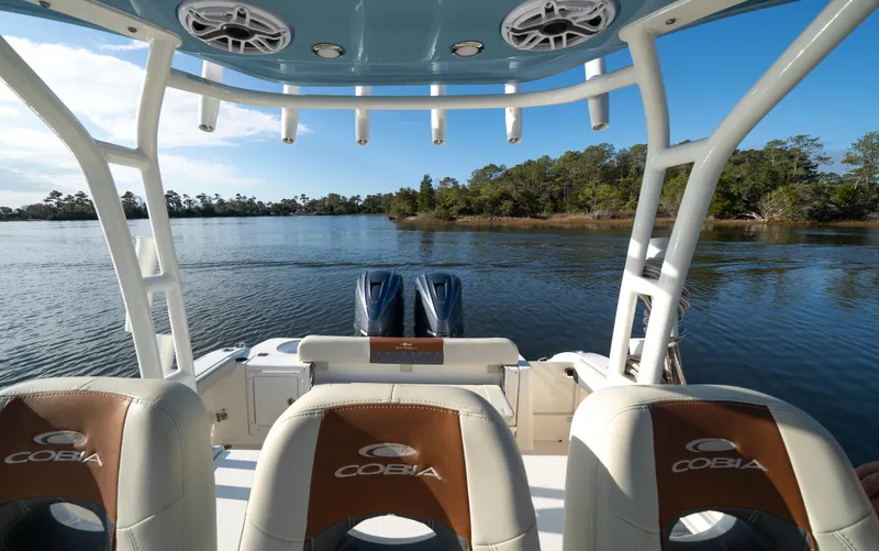 Slide: The Image of 2022 Cobia 350 Center Console boat on calm water, featuring luxurious seating and dual engines. - 5