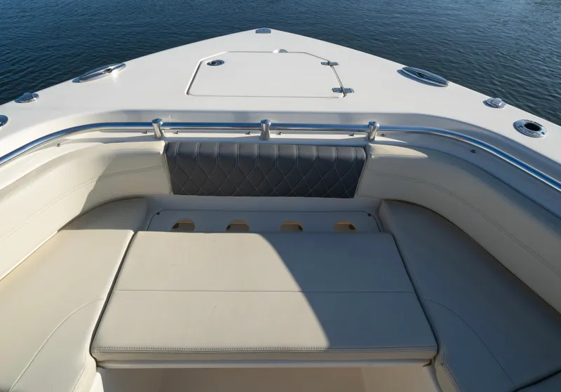 Slide: The Image of 2022 Cobia 350 Center Console boat with cushioned seating and storage, on calm water. - 9