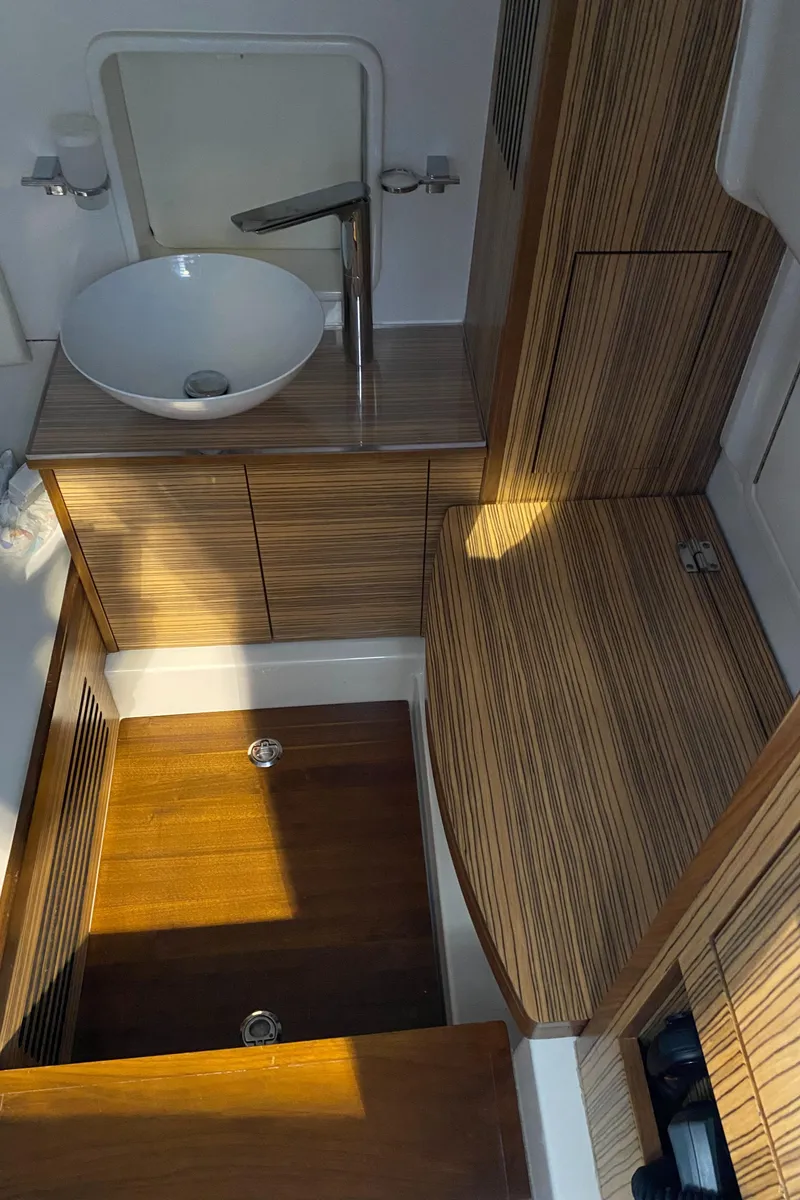 Slide: The Image of 2016 Chris-Craft Catalina 34 interior with modern wood finish and sleek sink design. - 14