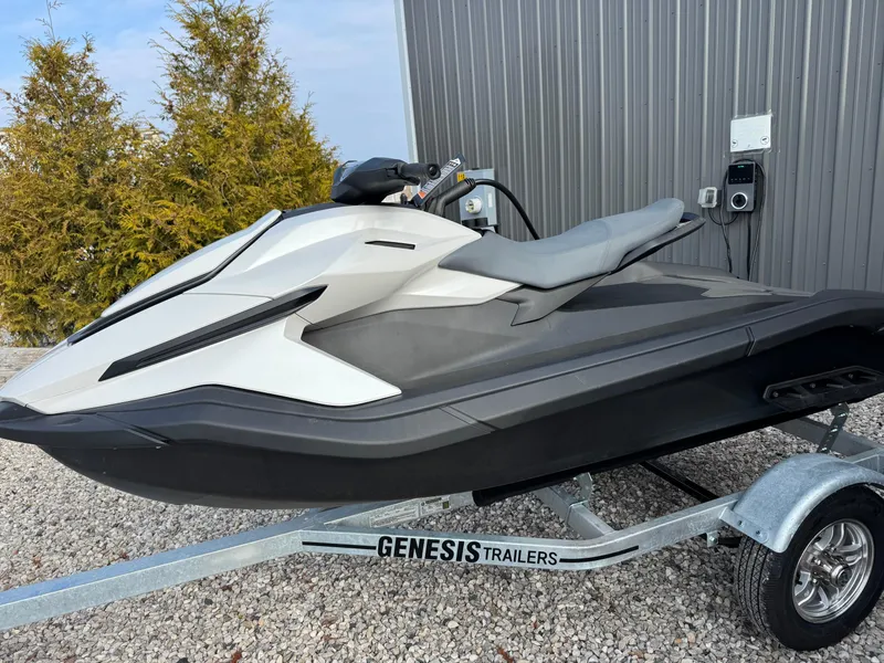 Slide: The Image of 2024 Taiga Orca jet ski on Genesis trailer, parked outdoors near a metal building. - 6