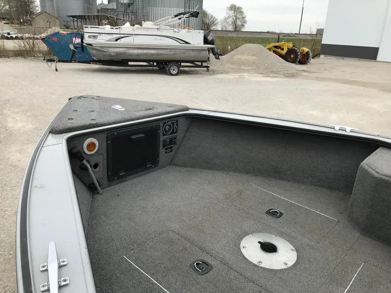 Slide: The Image of 1998 Lund 1775 Pro-V SE boat interior with carpeted deck and control panel. - 10