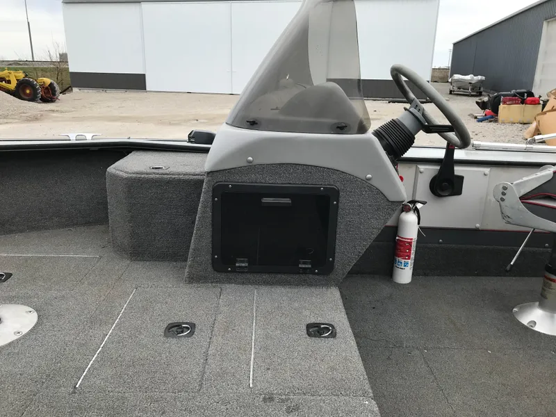 Slide: The Image of 1998 Lund 1775 Pro-V SE boat interior with steering console and fire extinguisher. - 11