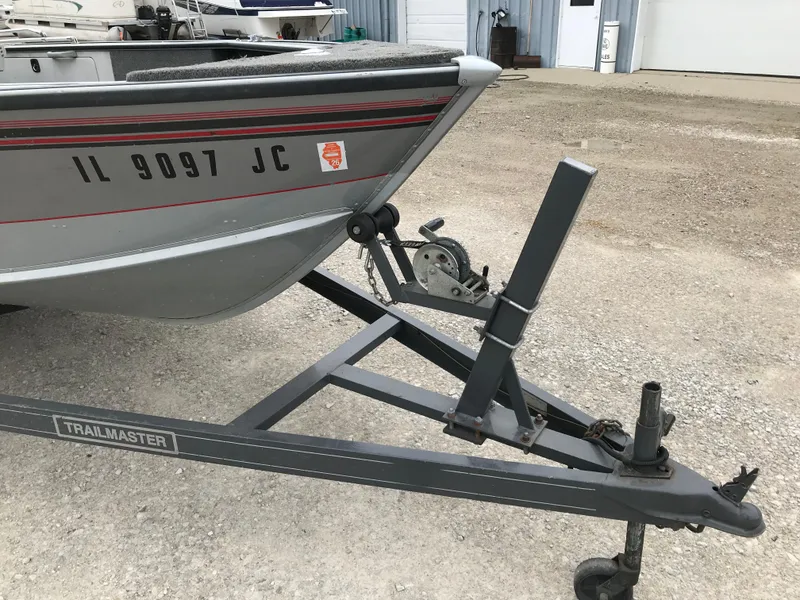 Slide: The Image of 1998 Lund 1775 Pro-V SE boat on a Trailmaster trailer, parked on gravel. - 14