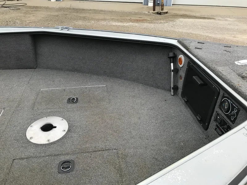 Slide: The Image of 1998 Lund 1775 Pro-V SE boat interior with gray carpet and storage compartments. - 15