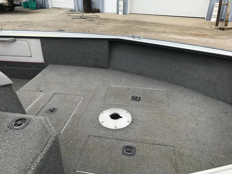 Slide: The Image of 1998 Lund 1775 Pro-V SE boat interior with carpeted deck and storage compartments. - 17