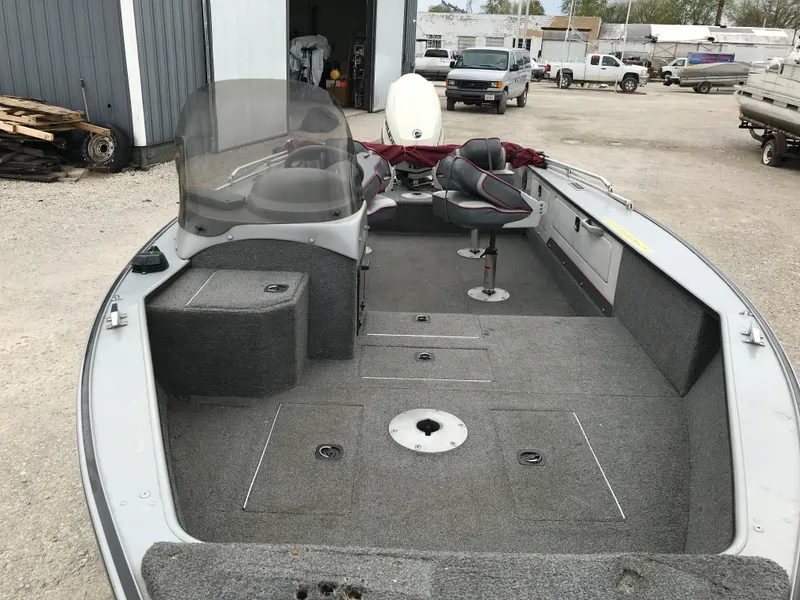 Slide: The Image of 1998 Lund 1775 Pro-V SE fishing boat with spacious deck and seating, parked outdoors. - 24