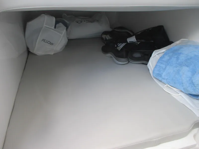 Slide: The Image of 2023 Sea Fox 328 Commander cabin storage with pillows, shoes, and towels. - 31