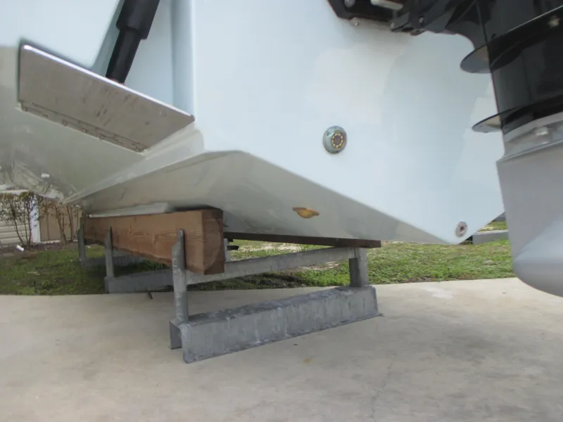 Slide: The Image of 2023 Sea Fox 328 Commander boat hull on a metal stand, viewed from below. - 8