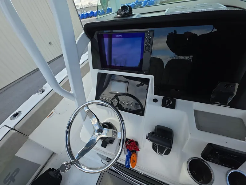 Slide: The Image of 2022 Sea Pro 239 Center Console helm with steering wheel and navigation display. - 6