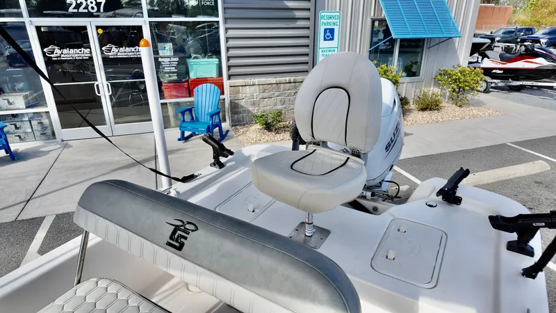 Slide: The Image of 2024 Carolina Skiff e18 JVX boat with seating, displayed outside a dealership. - 10