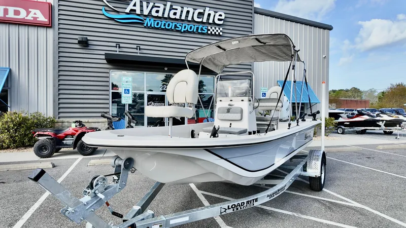 Slide: The Image of 2024 Carolina Skiff e18 JVX boat on trailer at Avalanche Motorsports dealership. - 2