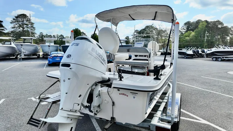 Slide: The Image of 2024 Carolina Skiff e18 JVX boat with outboard motor on trailer in parking lot. - 4