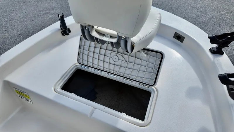 Slide: The Image of 2024 Carolina Skiff e18 JVX boat storage compartment with open hatch and seating. - 7
