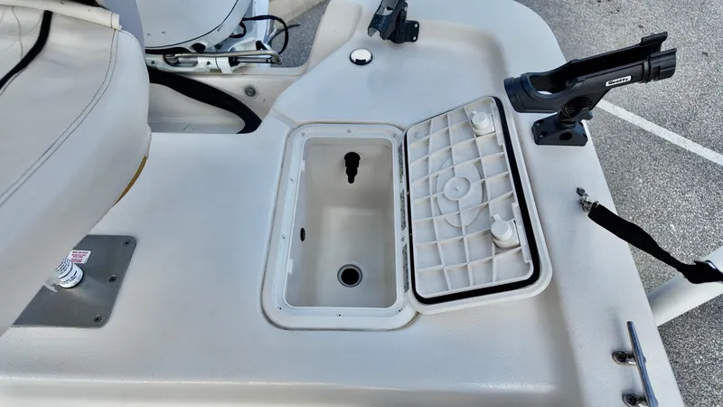 Slide: The Image of 2024 Carolina Skiff e18 JVX boat interior with open storage compartment and rod holder. - 8