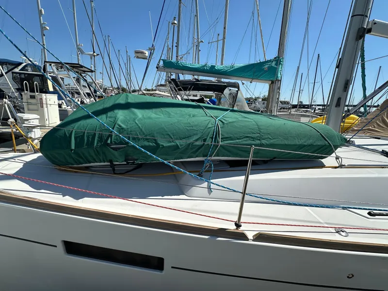 Slide: The Image of 2012 Beneteau Oceanis 41 sailboat with green cover, docked in a marina. - 7