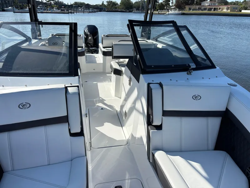 Slide: The Image of 2025 Cobalt R6 Outboard boat interior with sleek white seating and modern design on a calm lake. - 13