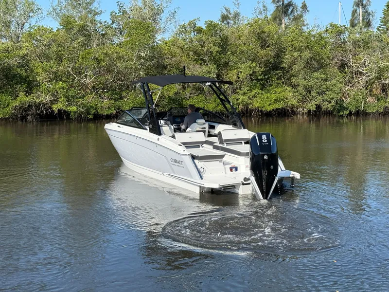 Slide: The Image of 2025 Cobalt R6 Outboard boat cruising on a calm river with lush greenery. - 4