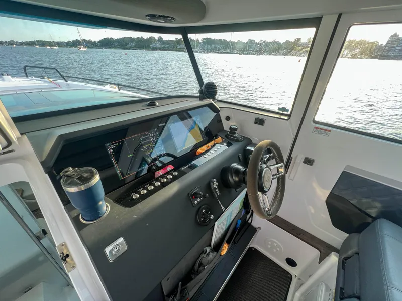 Slide: The Image of 2020 Axopar 37 XC helm with modern controls, overlooking a scenic water view. - 11
