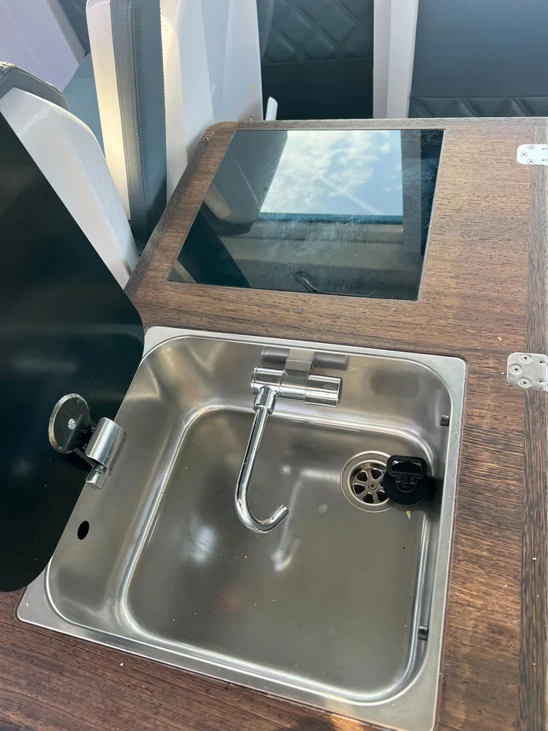 Slide: The Image of 2020 Axopar 37 XC boat interior with stainless steel sink and wooden countertop. - 14