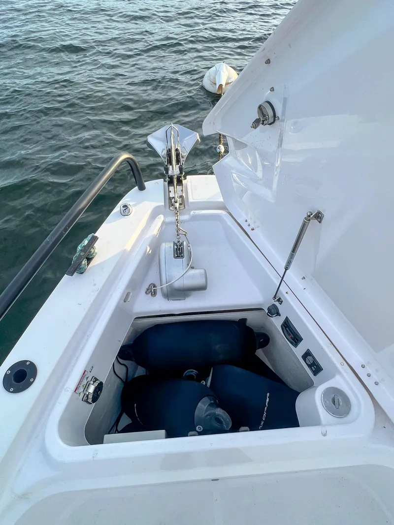 Slide: The Image of 2020 Axopar 37 XC boat anchor compartment with open hatch, docked on water. - 18