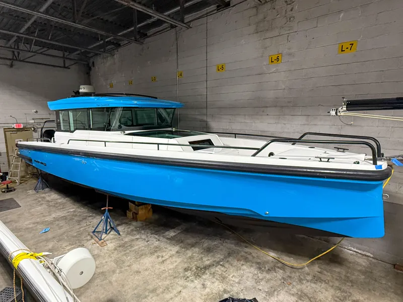 Slide: The Image of 2020 Axopar 37 XC boat in a garage, vibrant blue hull, sleek design. - 20