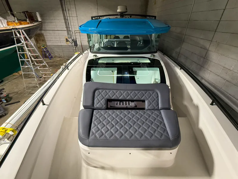 Slide: The Image of 2020 Axopar 37 XC boat with blue roof and quilted seating in a storage facility. - 21