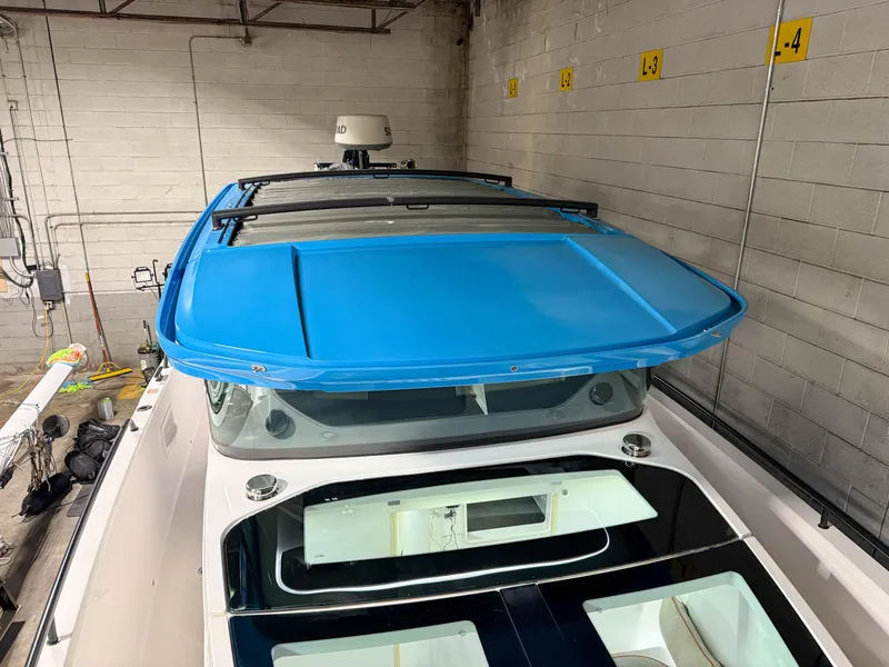 Slide: The Image of 2020 Axopar 37 XC boat with blue roof, stored indoors. - 23