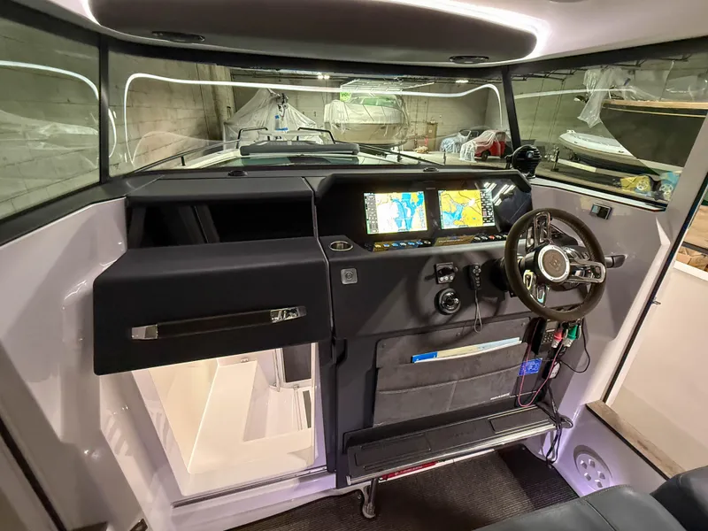 Slide: The Image of 2020 Axopar 37 XC helm with navigation screens and steering wheel in a modern cabin. - 31