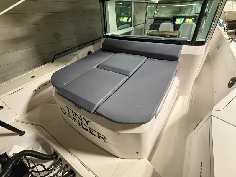 Slide: The Image of 2020 Axopar 37 XC boat with cushioned seating and sleek design in a showroom. - 46