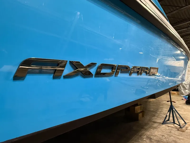 Slide: The Image of Blue 2020 Axopar 37 XC boat with logo in a storage facility. - 49