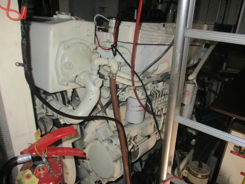 Slide: The Image of Engine room of 1994 Grand Banks 49 Motoryacht with visible machinery and fire extinguisher. - 11