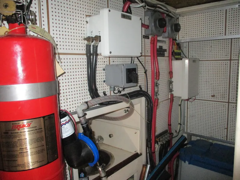 Slide: The Image of Engine room of 1994 Grand Banks 49 Motoryacht with fire extinguisher and electrical components. - 13