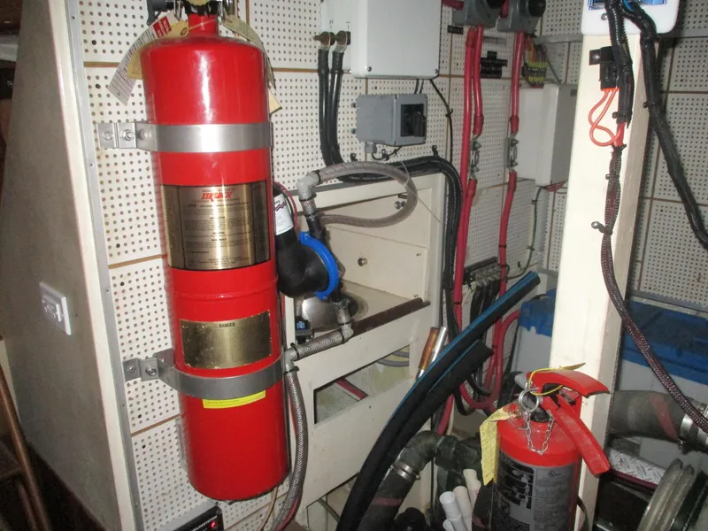 Slide: The Image of Engine room of 1994 Grand Banks 49 Motoryacht with fire extinguishers and equipment. - 27