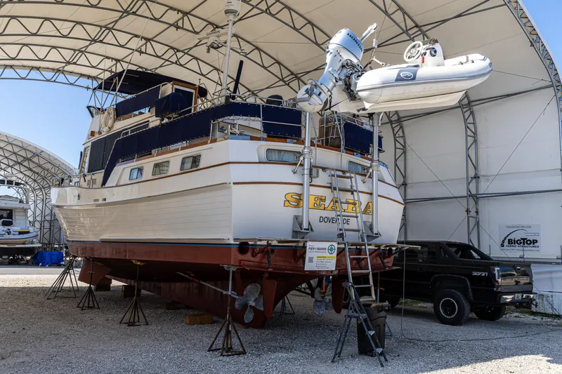 Slide: The Image of 1994 Grand Banks 49 Motoryacht in dry dock, covered storage, with a small boat on davits. - 40