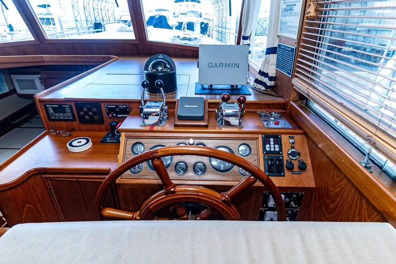 Slide: The Image of 1994 Grand Banks 49 Motoryacht helm with Garmin navigation and classic wooden steering wheel. - 45