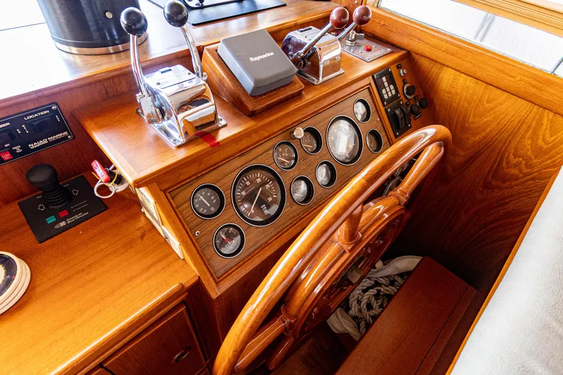 Slide: The Image of 1994 Grand Banks 49 Motoryacht helm with wooden steering wheel and control panel. - 46