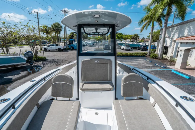 Slide: The Image of 2025 Sea Hunt Gamefish 25 boat interior with seating, parked outdoors under clear sky. - 28