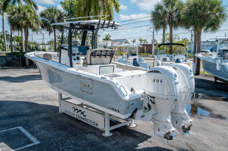 Slide: The Image of 2025 Sea Hunt Gamefish 25 boat with dual Yamaha engines, displayed outdoors under palm trees. - 4