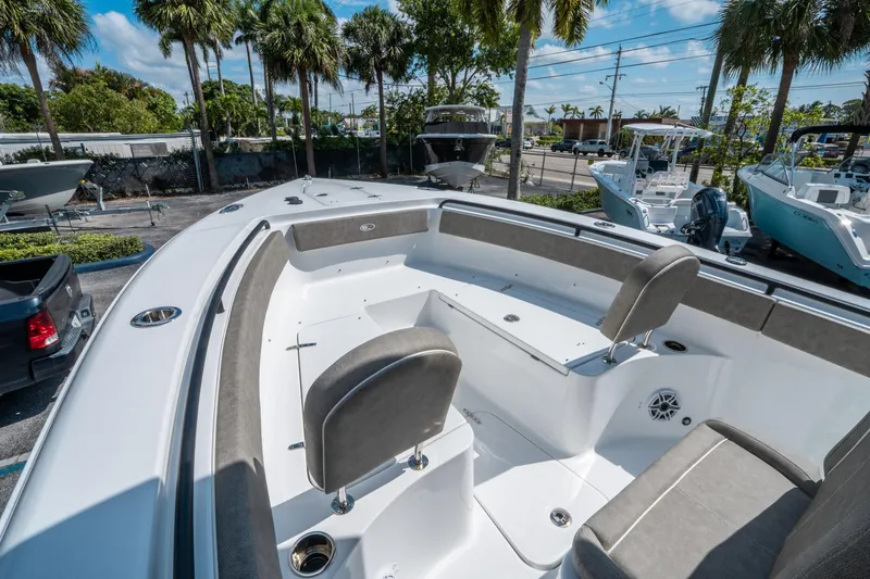 Slide: The Image of 2025 Sea Hunt Gamefish 25 boat interior with seating, surrounded by palm trees. - 29