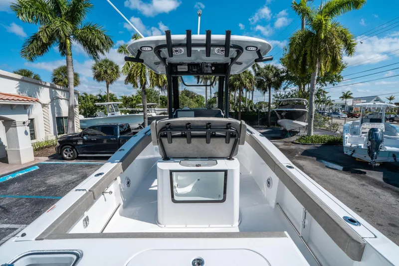 Slide: The Image of 2025 Sea Hunt Gamefish 25 boat with center console, parked under palm trees. - 9